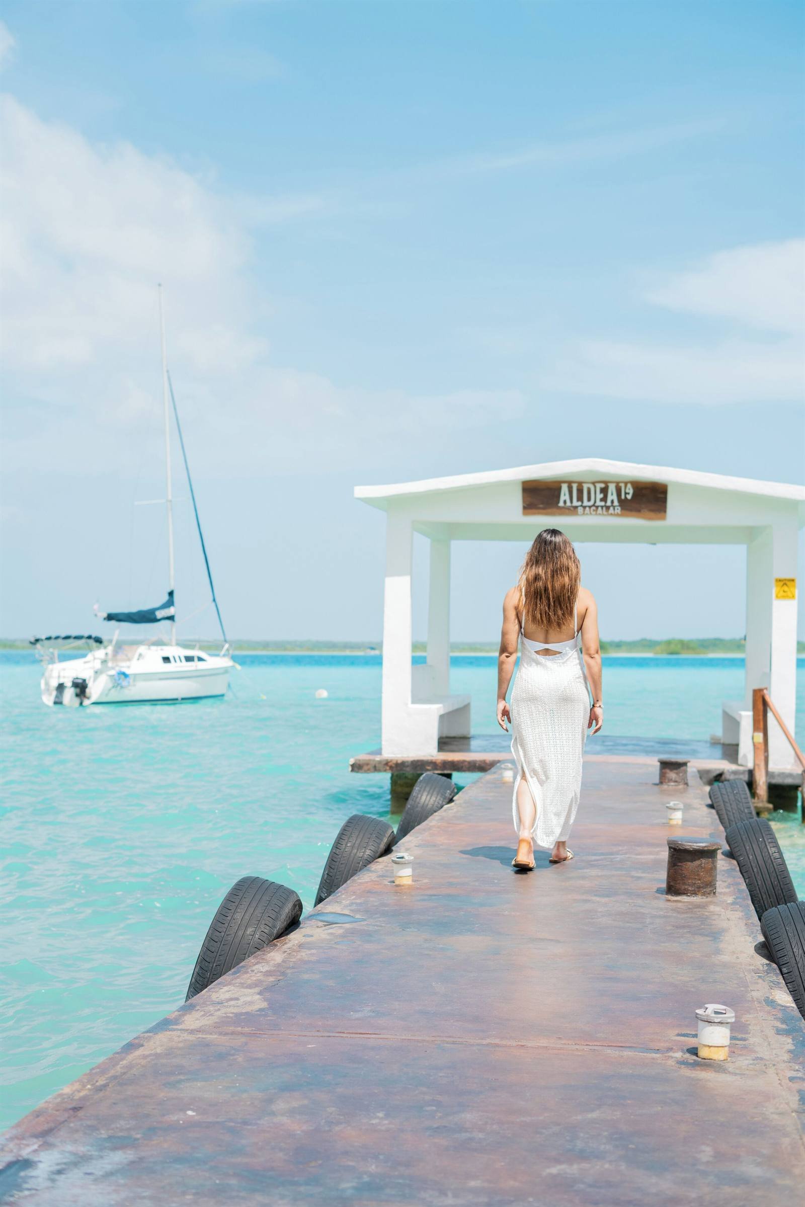 Aldea 19 Bacalar: wooden pier leading to the white palapa over the turquoise water