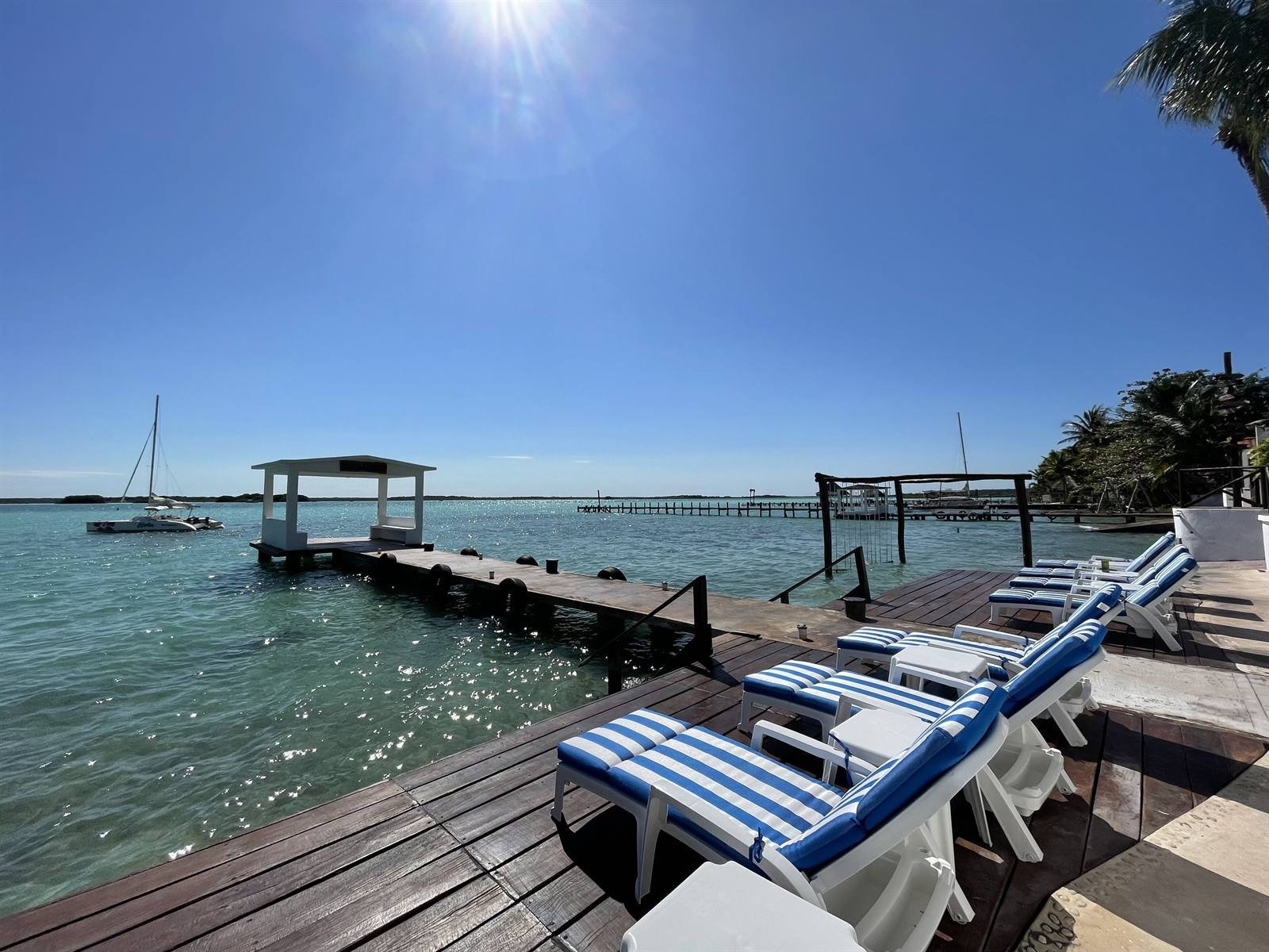 Aldea 19 Bacalar: sun loungers on the pier facing the calm lagoon