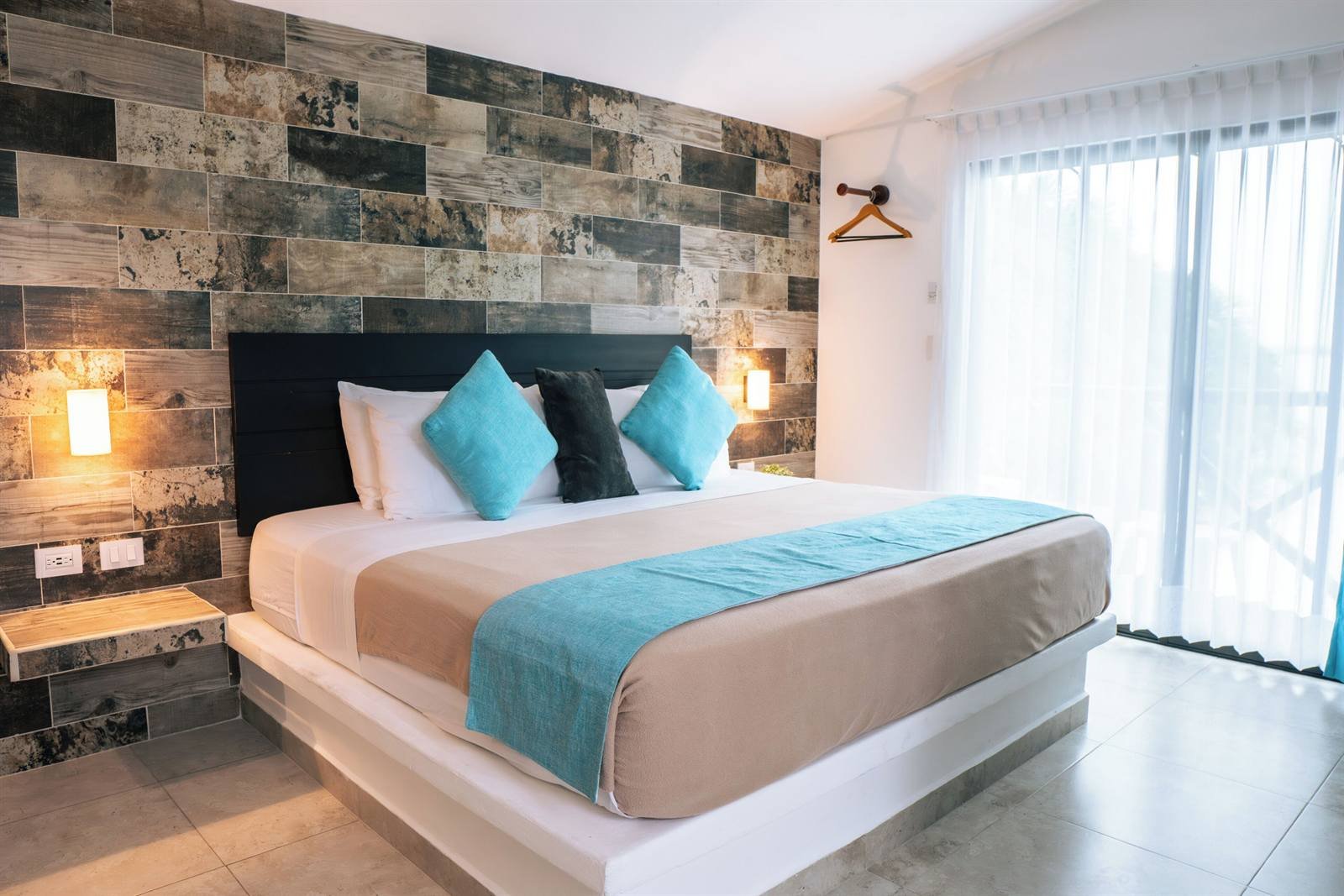 Aldea 19 Bacalar: room with a large bed and a wooden accent wall